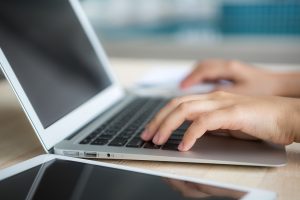 Closeup of business woman hand typing on laptop keyboard