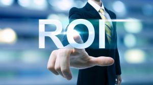 Businessman pointing at ROI (return on investment) on blurred city background